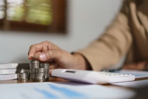 businesswoman-putting-a-coin-on-the-pile-of-coins-2025-03-09-11-59-59-utc-1